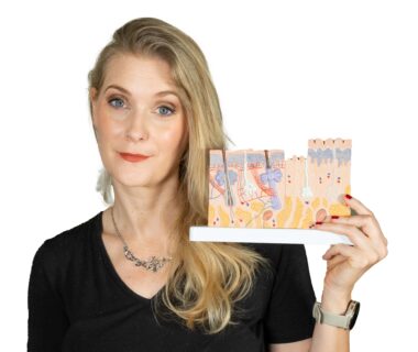 A blonde woman holding a skin model