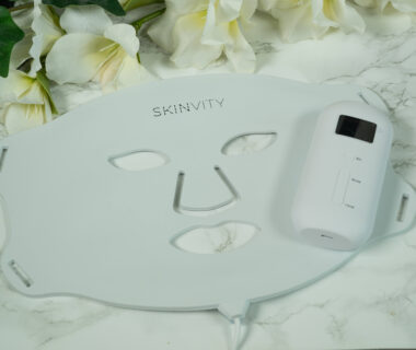 A SKINVITY LED face mask lying on a marble surface